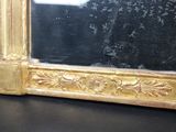 a mirror with a gold frame on a black table