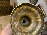 a person holding a gold vase in their hand