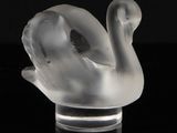 a glass sculpture of a swan on a black surface