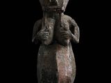 un gros plan d'une statue sur fond noir, avec un fond noir