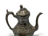 an old teapot with a bird on top of it on a white surface