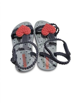 une paire de tongs grises et rouges ornées d'un cœur rouge