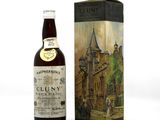 the bottle of cluny is next to a box of wine