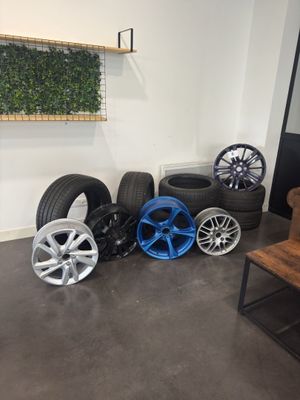 wheels and tires are lined up on the floor in a room