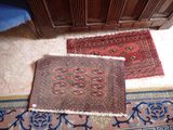 deux tapis posés à même le sol dans une pièce où se trouvent une armoire et une chaise bleue