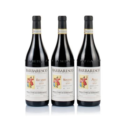 three bottles of red wine sitting next to each other on a white surface
