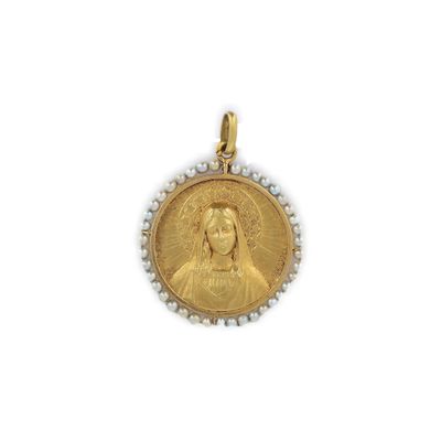 un gros plan d'une médaille d'or ornée de perles sur fond blanc