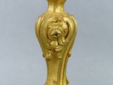 a gold vase with a bird on top of it