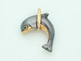 a silver and gold dolphin with green eyes on a white surface