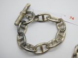 un bracelet en argent et un autre bracelet en argent posés sur une table blanche