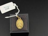 a small gold medal on a black box with a tag