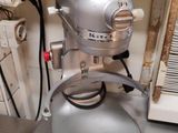 un mixeur argenté posé sur le plan de travail de la cuisine, à côté de l'évier
