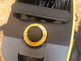 a black and yellow vacuum with a yellow button on it