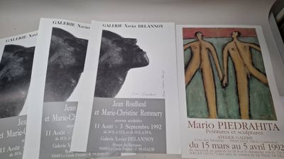 quatre affiches posées sur une étagère, représentant un ours et un homme
