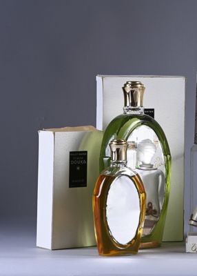 three bottles of perfume sitting on top of a table next to a box