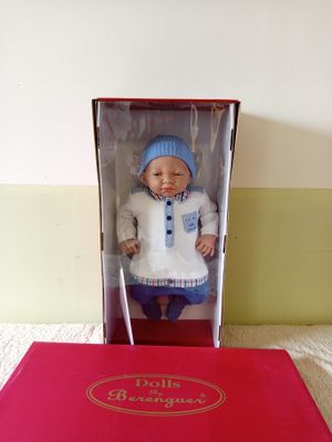 a doll in a box that is sitting on a bed