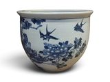 a blue and white bowl with birds flying in the sky