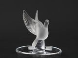 an image of a glass bird sitting on top of a glass plate