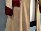 an image of a beige coat with red trims on a mannequin dummy