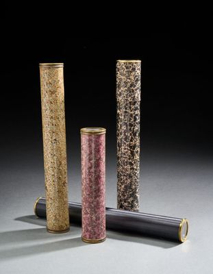 trois tubes de couleurs différentes sont alignés sur une surface grise