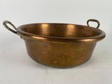 une vieille casserole en cuivre avec des poignées, sur fond blanc