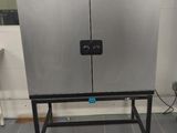 a stainless steel cabinet in the middle of a tiled floor