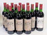 six bottles of red wine lined up in a row on a white surface