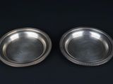 deux assiettes en argent sur fond noir