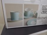 a box of tea cups and saucers sitting on a table