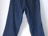 navy blue pants hanging on a hanger on a white wall