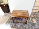 une table en bois posée sur un tapis dans une pièce