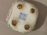 a white dice with yellow dots on it sitting on a table