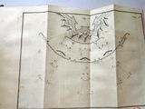 someone is holding an old book with a drawing of a bird on it
