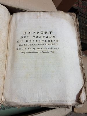un vieux livre posé au sommet d'une pile de livres