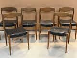 quatre chaises aux assises en cuir noir devant un mur beige