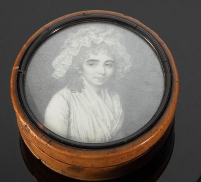 portrait d'une femme coiffée d'un bonnet, dans un coffret en bois