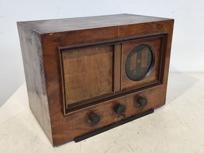 une vieille radio en bois posée sur une table blanche