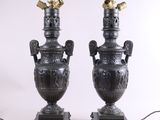 paire d'urnes antiques en bronze, munies d'anses et posées sur des socles