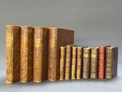 several old books are lined up in a row on a gray surface