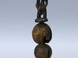 une image représentant une sculpture en bois représentant une personne assise sur une boule