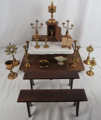 a small table with a bench and some candles on it