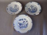 trois assiettes bleues et blanches à motifs posées sur une table