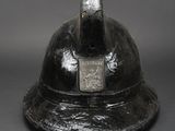 an old fireman ' s helmet on a gray background