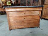 a wooden dresser with a marble top in the middle of a room