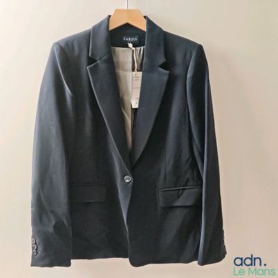 the jacket is hanging on a hanger on the wall