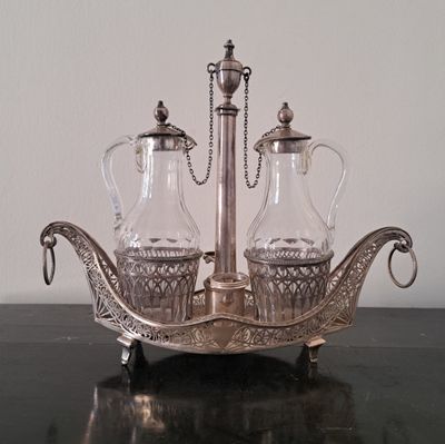 un plateau en argent sur lequel sont posés une carafe en verre et deux pichets en verre
