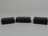 trois boîtes en plastique noir posées sur une surface blanche