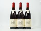 trois bouteilles de vin rouge posées sur une table blanche