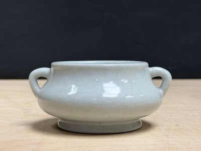 a small white bowl sitting on a wooden table