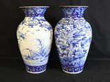 two blue and white vases sitting on a black background